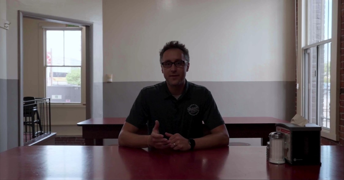 Documentary interview subject seated at a restaurant table